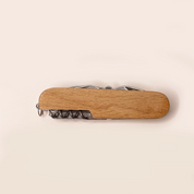 Wooden multi-tool with corkscrew on a beige background